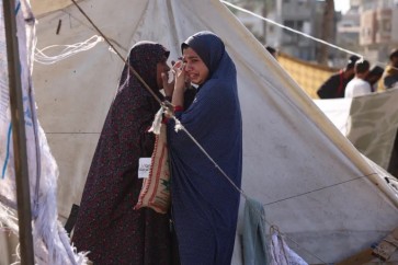 بكاء وفزع بعد استهداف الاحتلال خيمة نازحين في دير البلح وسط قطاع غزة (الفرنسية)